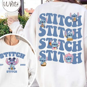 May include: White sweatshirt featuring the word "Stitch" in blue, repeated four times down the back, with cartoon Stitch characters. The front of the sweatshirt has a smaller graphic of Stitch with text that reads "Stitch EST 2002".