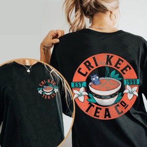 May include: Black t-shirt with a circular graphic of a teacup with a cartoon cricket inside. The graphic has the text "Crikee Tea Co." and "Est. 1998".