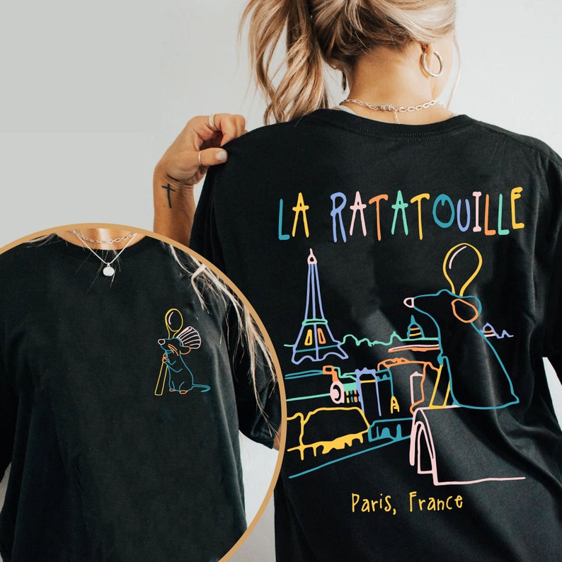 May include: Black t-shirt with a colorful graphic of Remy the rat from the movie Ratatouille, standing on a rooftop in Paris, France. The text "La Ratatouille" is above the graphic and "Paris, France" is below.