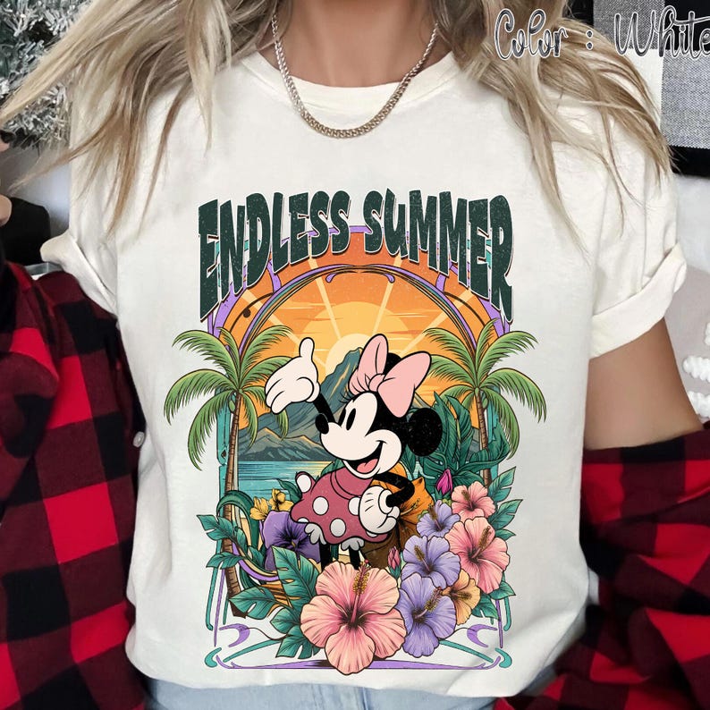 May include: White t-shirt featuring a colorful graphic of Minnie Mouse in a tropical setting. The design includes palm trees, flowers, and the text "ENDLESS SUMMER" in a stylized font. The shirt has short sleeves.