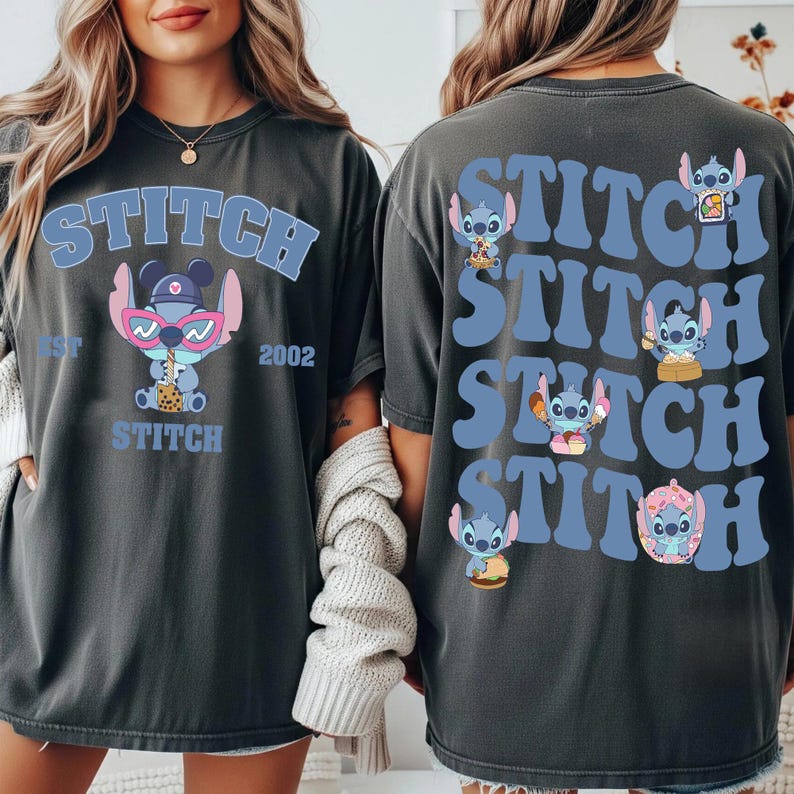 May include: Dark gray t-shirt featuring the word "STITCH" in light blue, with a cartoon character wearing sunglasses and holding a drink. The back of the shirt repeats "STITCH" with different Stitch illustrations.