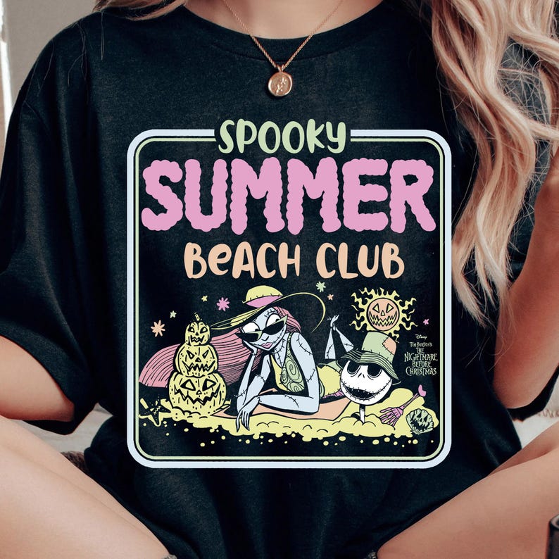 May include: Black t-shirt with a rectangular graphic featuring the text "SPOOKY SUMMER BEACH CLUB" in pink and white. The graphic includes illustrations of characters from "The Nightmare Before Christmas" enjoying a beach scene.