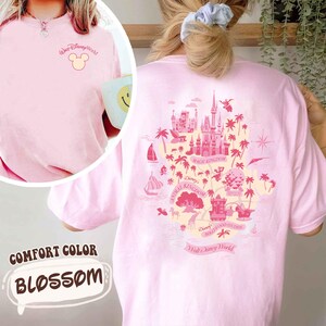 May include: Pink Comfort Color t-shirt with a Disney World graphic on the back. The front of the shirt has the words "Walt Disney World" and a Mickey Mouse head. The shirt is a light pink color and has the word "Blossom" on the bottom.