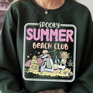 May include: Dark green sweatshirt with a graphic that reads "Spooky Summer Beach Club." The graphic features illustrations of characters from The Nightmare Before Christmas enjoying a beach scene. The sweatshirt is a crew neck style.