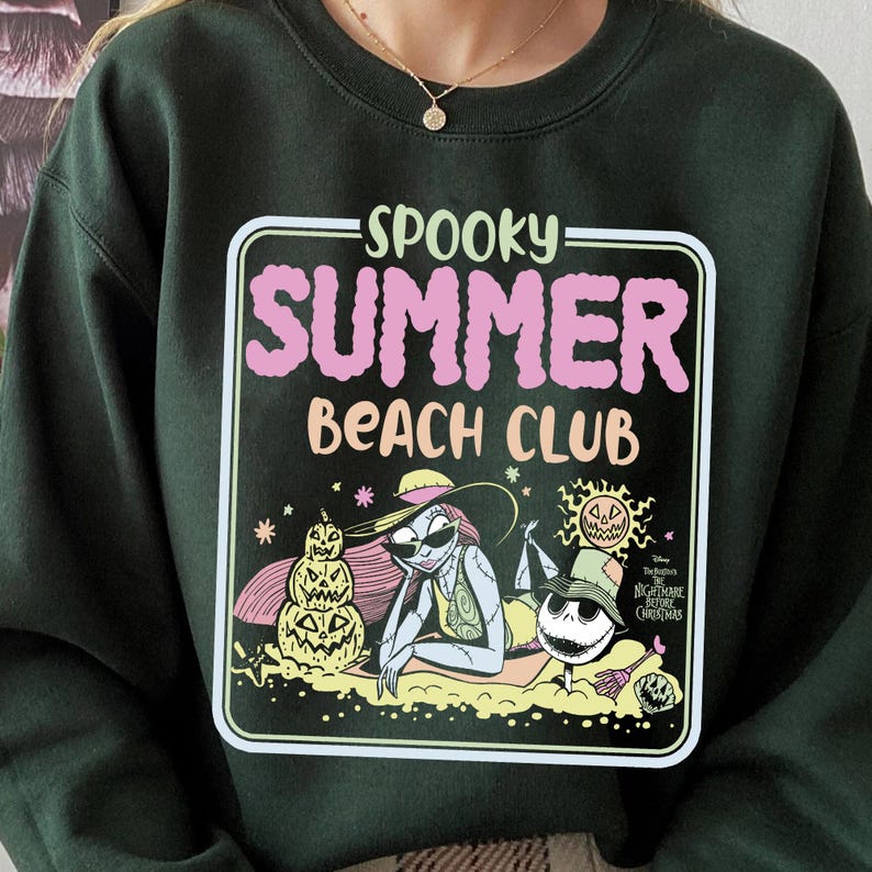 May include: Dark green sweatshirt with a graphic that reads "Spooky Summer Beach Club." The graphic features illustrations of characters from The Nightmare Before Christmas enjoying a beach scene. The sweatshirt is a crew neck style.
