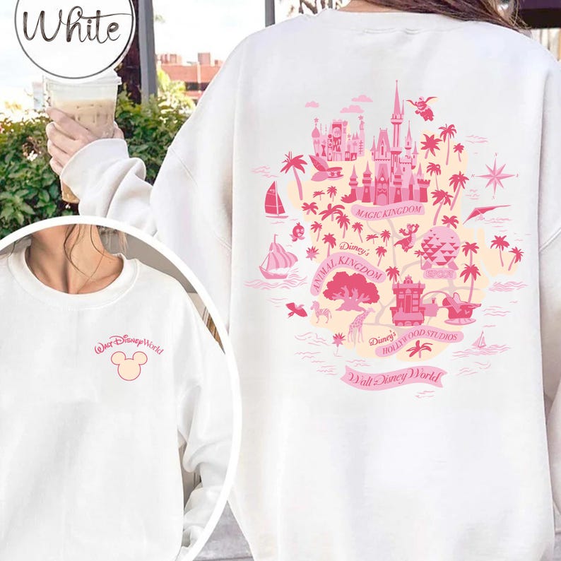 May include: White sweatshirt featuring a pink map of Walt Disney World attractions on the back, including Magic Kingdom, Animal Kingdom, and Hollywood Studios. The front has a small pink Mickey Mouse graphic and "Walt Disney World" text.