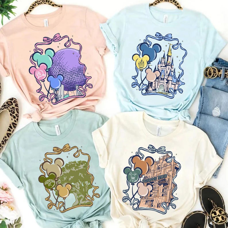 May include: Four pastel-colored t-shirts with Disney theme park graphics. Each shirt features a different park icon, including Spaceship Earth, Cinderella Castle, the Tree of Life, and the Tower of Terror, with Mickey Mouse balloon accents.