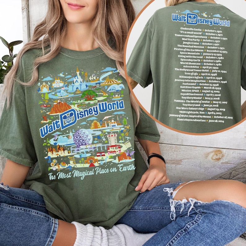 Pu&ograve; includere: Una maglietta verde con una stampa grafica di monumenti di Walt Disney World e il testo "Walt Disney World" e "The Most Magical Place on Earth". Il retro della maglietta elenca le date di apertura di varie attrazioni di Disney World.