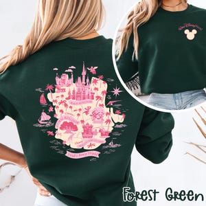 May include: Forest green sweatshirt featuring a pink map of Walt Disney World with park names. The back of the sweatshirt displays a detailed map of the park with illustrations of landmarks. The front has a small pink Mickey Mouse head and "Walt Disney World" text.