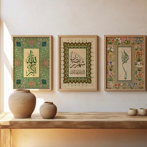 May include: Three framed Islamic calligraphy art prints. The prints feature ornate borders and Arabic script in green and black on a beige background. The frames are light wood. Two ceramic vases and three small bowls sit on a wooden table.