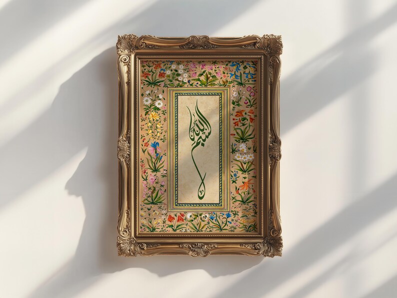 May include: A framed artwork featuring Arabic calligraphy in green on a beige background. The frame is ornate, gold-colored, and rectangular. The artwork is surrounded by a floral border with various colorful flowers. The artwork is displayed against a white wall.