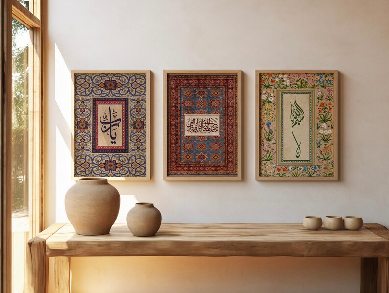 May include: Three framed art prints with Arabic calligraphy and ornate patterns. The prints are in wooden frames and feature intricate designs in shades of blue, red, and floral motifs. The artwork is displayed on a wooden table with two ceramic vases and three small cups.
