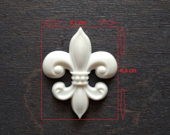 May include: White plastic fleur-de-lis ornament measuring 5.1 inches wide and 6.3 inches tall.