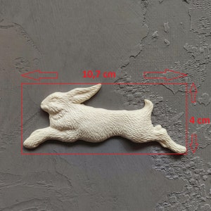 May include: A white ceramic rabbit figurine, 10.7 inches long and 4 inches tall, running in a leaping pose.