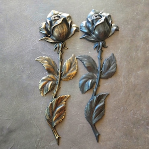 May include: Two decorative rose wall decor pieces, one gold and one black, with detailed carvings of leaves and stems.