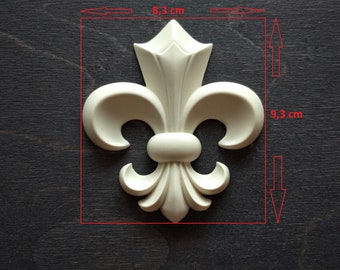 May include: A white, decorative fleur-de-lis ornament measuring 8.3 inches by 9.3 inches. The ornament is made of a smooth, white material and has a detailed design.