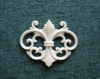 May include: White decorative trim with a scroll design. The trim is made of a lightweight material and has a smooth finish.