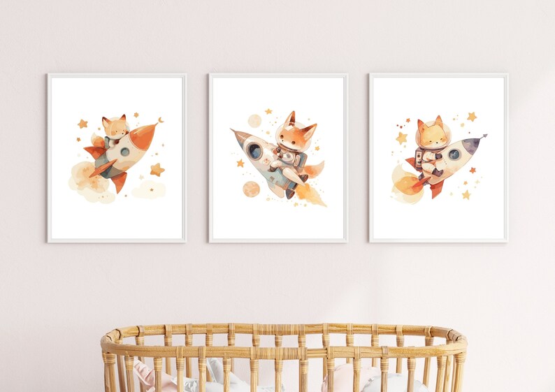 May include: Set of three framed watercolor prints featuring a fox in a rocket ship. The fox is depicted in a spacesuit, surrounded by stars and planets. The rocket is orange and white, with a trail of smoke.