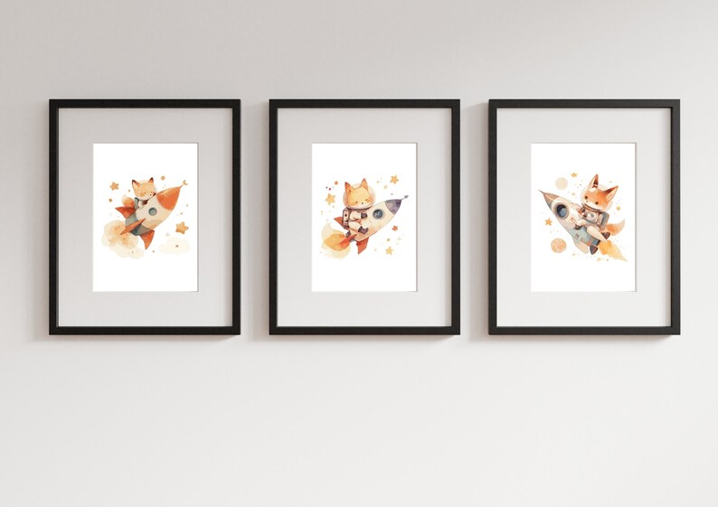 May include: Set of three framed art prints featuring watercolor illustrations of a fox in a rocket ship. The fox is depicted in various poses, surrounded by stars and planets. The prints are framed in black.
