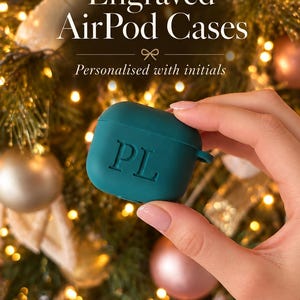 K&ouml;nnte beinhalten: Eine teal-farbene Silikon-Schutzh&uuml;lle f&uuml;r AirPods mit den eingravierten Initialen PL auf der Vorderseite. Der Text Engraved AirPod Cases und Personalised with initials ist oben im Bild &uuml;ber der teal-farbenen H&uuml;lle zu sehen.