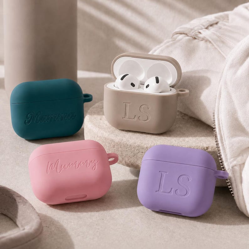 K&ouml;nnte beinhalten: Vier Silikon-Kopfh&ouml;rerh&uuml;llen in Blaugr&uuml;n, Beige, Rosa und Lila. Die blaugr&uuml;ne H&uuml;lle tr&auml;gt das Wort Mamma, die rosa H&uuml;lle zeigt Mummy, und die beige sowie die lila H&uuml;lle sind mit den Buchstaben LS gepr&auml;gt. Die beige H&uuml;lle ist offen und zeigt wei&szlig;e Ohrh&ouml;rer.