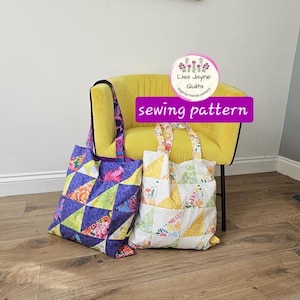 Könnte beinhalten: Zwei gesteppte Tragetaschen mit floralen und geometrischen Mustern. Eine Tasche hat ein lila-blaues Design, während die andere ein weiß-gelbes Muster hat. Die Taschen stehen auf einem Holzboden in der Nähe eines gelben Sessels. Der Text "sewing pattern" ist sichtbar.