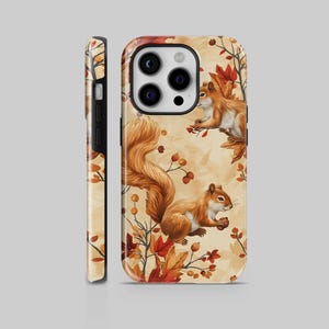 Op de afbeelding: Een telefoonhoesje met een herhaald patroon van eekhoorns, herfstbladeren en bessen. De eekhoorns zijn bruin en oranje, tegen een beige achtergrond. De hoes wordt van voren en van de zijkant getoond.