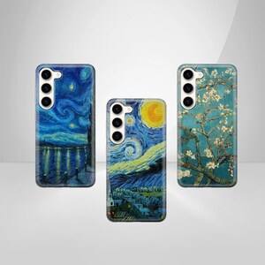 May include: Three phone cases with different designs. The first case features a starry night sky with a yellow moon and a village in the foreground. The second case features a starry night sky with a yellow moon and a village in the foreground. The third case features a blue sky with a white tree and white flowers.