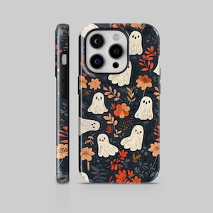 Può includere: Una custodia per telefono nera con un motivo di fantasmi bianchi e fiori arancioni. La custodia ha un ritaglio per la fotocamera e un bordo nero.
