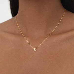 Peut inclure: Un délicat collier en or avec un petit pendentif en forme de lettre "B". Le pendentif est suspendu à une fine chaîne. Le collier est un bijou simple et élégant, de couleur or.