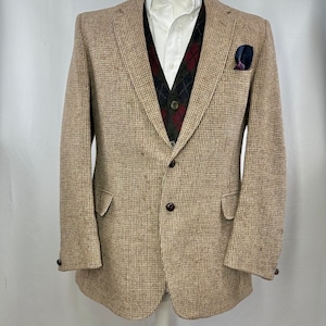 Peut inclure: Un blazer en tweed marron à motif à carreaux marron et blanc. Le blazer a une fermeture à bouton unique et deux poches.