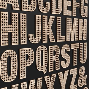 The full Alphabet of wooden letters with each letter having a rattan pattern cut out of the middle of it.