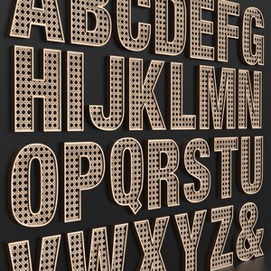 The full Alphabet of wooden letters with each letter having a rattan pattern cut out of the middle of it.