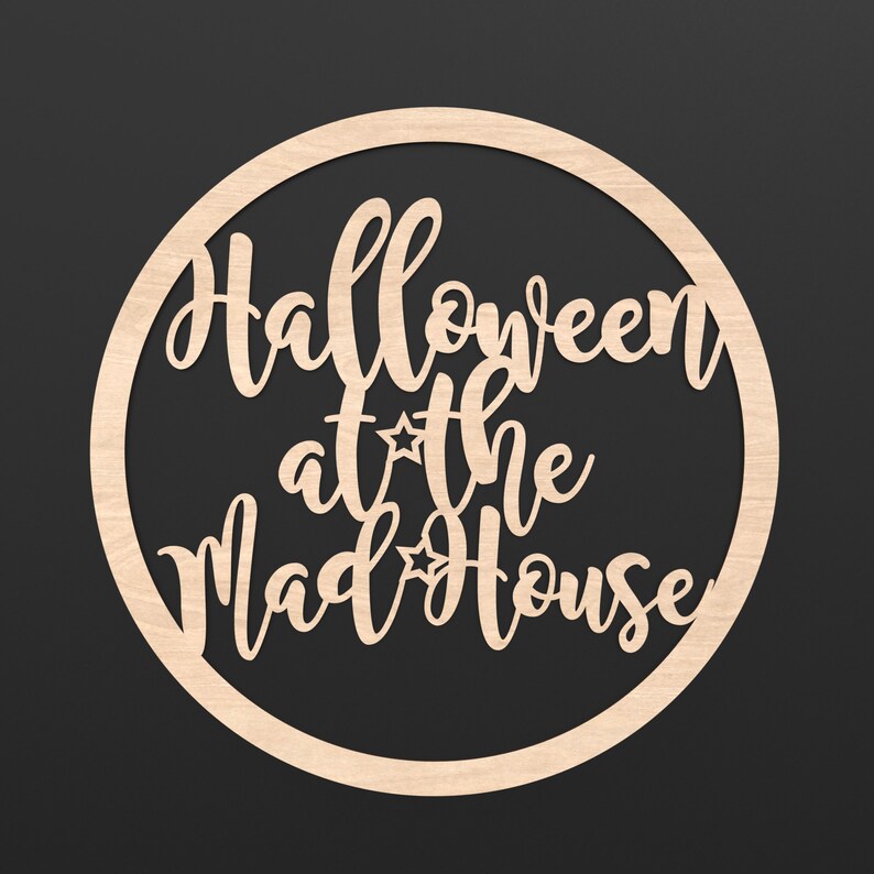 A wooden Circle Hoop with the wording Halloween at the Madhouse cut out of the centre of it.