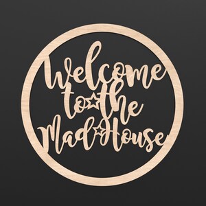 A wooden Circle Hoop with the wording Welcome to the Madhouse cut out of the centre of it.