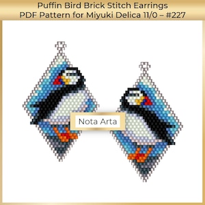 May include: A pair of beaded earrings featuring a brick stitch design of a puffin bird. The earrings are diamond shaped and have a blue, white, and orange color scheme. The earrings are labeled "Nota Arta" and are for Miyuki Delica 11/0 beads.