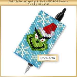 以下が含まれることがあります： 青い背景に白い雪片が散りばめられ、赤いサンタ帽子の緑色のグリンチの顔が描かれています。この画像は、ペンのラッピング用のビーズパターンです。右下に「Nota Arta」というテキストがあります。