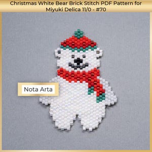May include: White bead bear wearing a red and green hat and scarf. The bear is made with Miyuki Delica beads and is a brick stitch pattern. The text "Nota Arta" is in the bottom left corner of the image.
