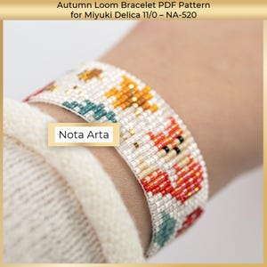 Puede incluir: Una pulsera de cuentas con un patr&oacute;n de tem&aacute;tica oto&ntilde;al, con detalles en naranja, rojo y turquesa. La pulsera est&aacute; hecha con cuentas Miyuki Delica. El texto "Nota Arta" es visible.