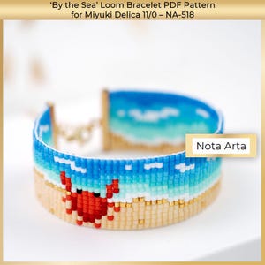 May include: A beaded loom bracelet with a beach theme. The bracelet features a blue and white ocean design, a tan sandy beach, and a red crab. The bracelet is made with small beads and has gold-colored clasps. The text "Nota Arta" is visible.