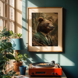 Può includere: Una stampa artistica incorniciata con un orso in giacca e cravatta. L'opera d'arte è esposta su una parete turchese sopra un giradischi arancione. La stanza è illuminata dalla luce naturale di una finestra vicina, con piante in vaso.