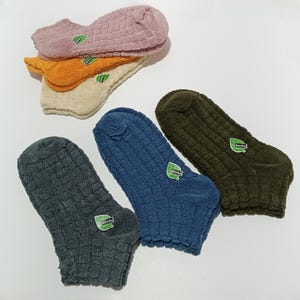 six pairs of colorful socks with textured patterns displayed on a white surface.