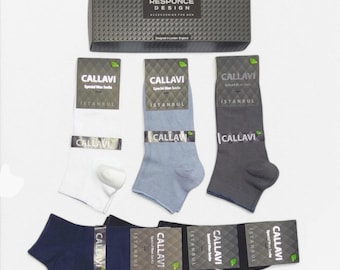 Può includere: Un set di cinque paia di calzini in una scatola. I calzini sono di diversi colori: bianco, azzurro, grigio, blu scuro e nero. La scatola è nera con un motivo argentato e il testo "RESPONCE DESIGN" su di essa. I calzini hanno il testo "CALLAVI" e "ISTANBUL" sulla confezione.