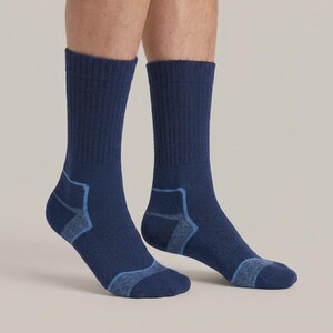 May include: A pair of mid-calf crew socks in a deep navy blue color. The socks feature a ribbed texture along the leg and reinforced, lighter blue panels at the heel and toe areas. The fabric appears to be a knit material with a consistent weave.