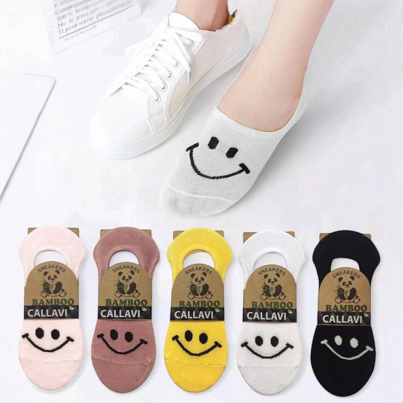 Colorful bamboo ankle socks with smiley face designs and casual white sneakers. Each sock features eco-friendly bamboo material branding from. Perfect for stylish and comfortable footwear options.