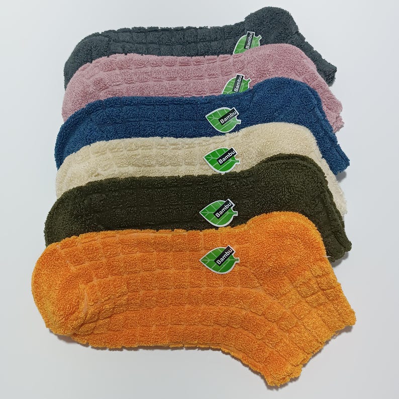 A stack of colorful ankle socks with visible brand tags.