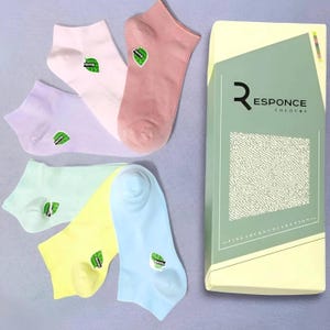 May include: A set of six pastel-colored ankle socks with a green leaf logo. The socks are packaged in a box with the text "RESPONCE COLORS FINE SOCKS COLLECTION".