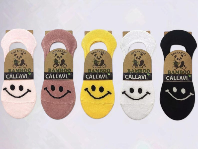 Five pairs of colorful bamboo socks with smiley faces in pink, mauve, yellow, white, and black, displayed on a white background.