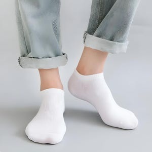 Close-up image of a person's feet wearing white ankle socks and rolled-up jeans, perfect for casual and comfortable fashion.