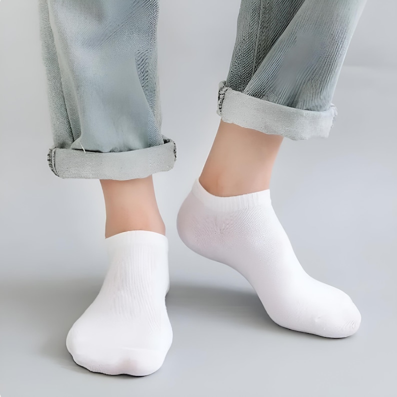 Close-up image of a person's feet wearing white ankle socks and rolled-up jeans, perfect for casual and comfortable fashion.